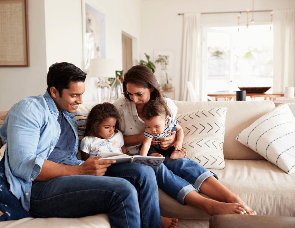 Family reading a book with their children