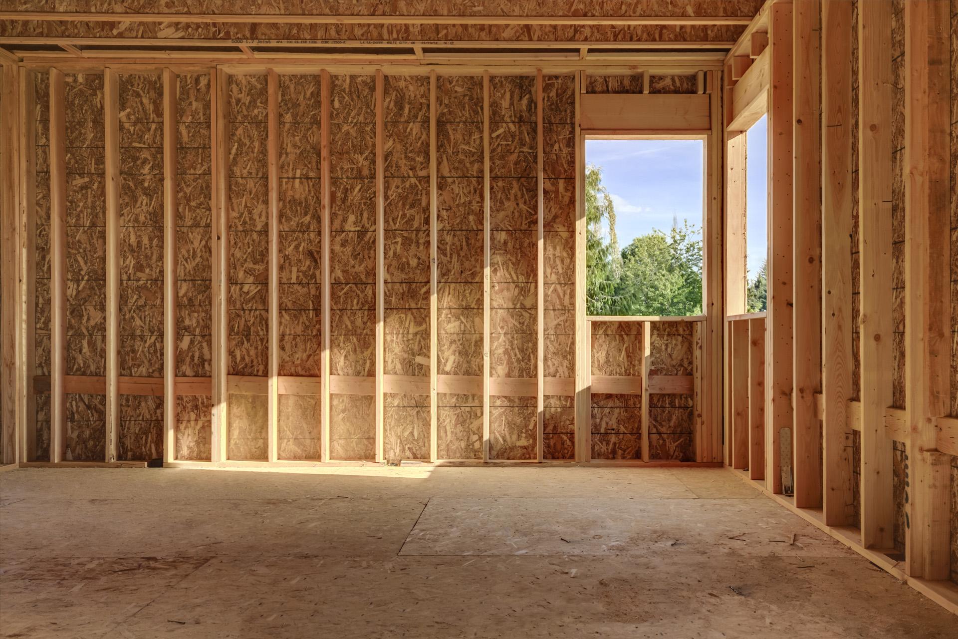 Interior of a bare wood frame room with light entering from a window